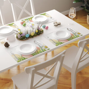 stół zastawiony kilkoma podkładkami z motywem pisanek, talerzami i sztućcami