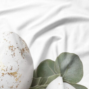 Detale nadruku: biały pisankowy motyw z subtelnymi złotymi akcentami i liśćmi eukaliptusa na tkaninie