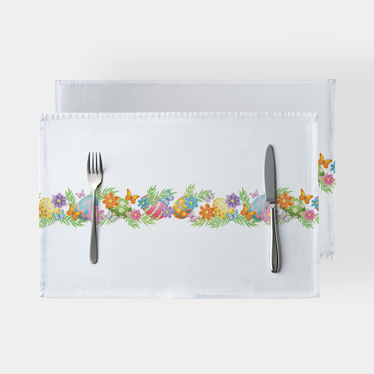 Główne ujęcie białej podkładki z poziomą girlandą pisanek, kwiatów i motyli