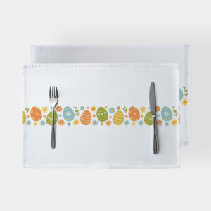 Biały podkład z poziomym pasem kolorowych pisanek i drobnych kwiatków, widok z góry