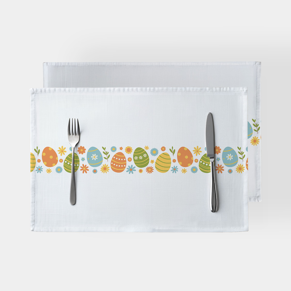 Biały podkład z poziomym pasem kolorowych pisanek i drobnych kwiatków, widok z góry