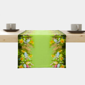 jasnozielony bieżnik rozłożony na stole z brzegami zdobionymi żonkilami i pastelowymi pisankami