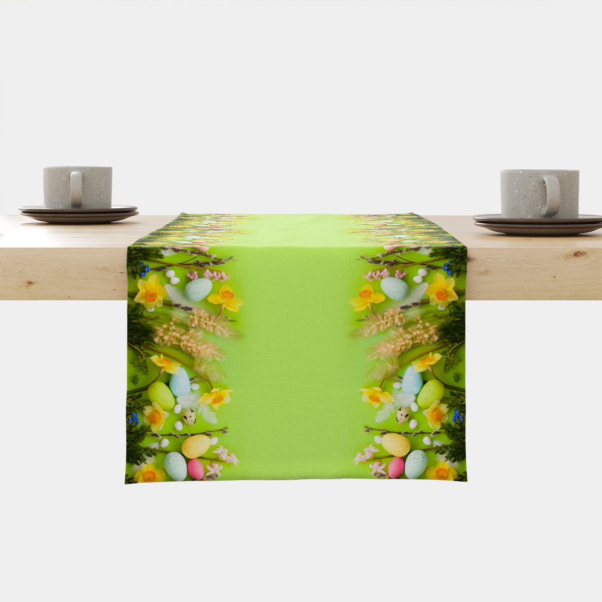 jasnozielony bieżnik rozłożony na stole z brzegami zdobionymi żonkilami i pastelowymi pisankami