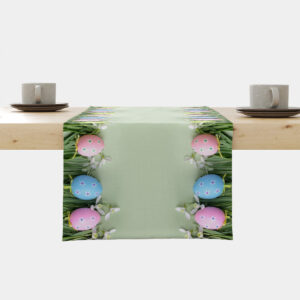 Bieżnik ułożony na drewnianym stole z pastelowo zielonym tłem i krawędziami ozdobionymi kolorowymi pisankami w trawie