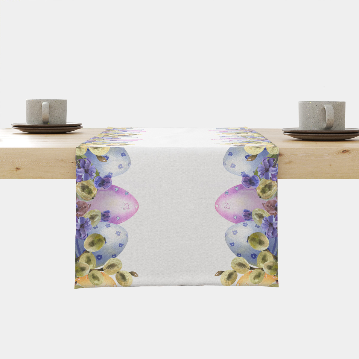 Bieżnik na drewnianym stole z akwarelowymi pisankami i bazami przy krawędziach