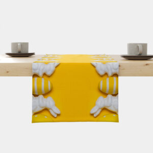 żółty bieżnik z białymi króliczkami i żółto-białymi pisankami ułożony na drewnianym stole, widok frontalny