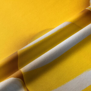 zbliżenie na fakturę tkaniny i biało-żółte pasy wzoru, detal materiału