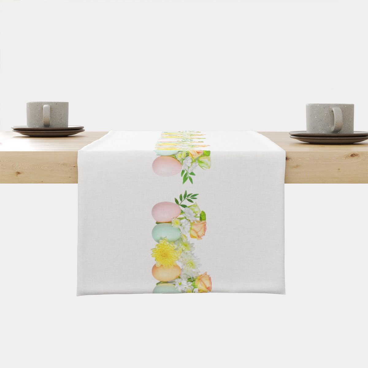 Bieżnik na stole z centralnym paskiem pastelowych jajek i kwiatów na białym tle