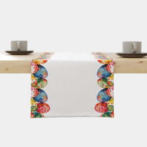 biały bieżnik z kolorowymi akwarelowymi pisankami ułożonymi przy krawędziach na drewnianym stole