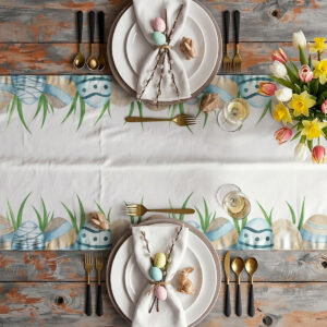 Aranżacja stołu z bieżnikiem, talerzami, sztućcami i wiosennym bukietem żonkili oraz tulipanów