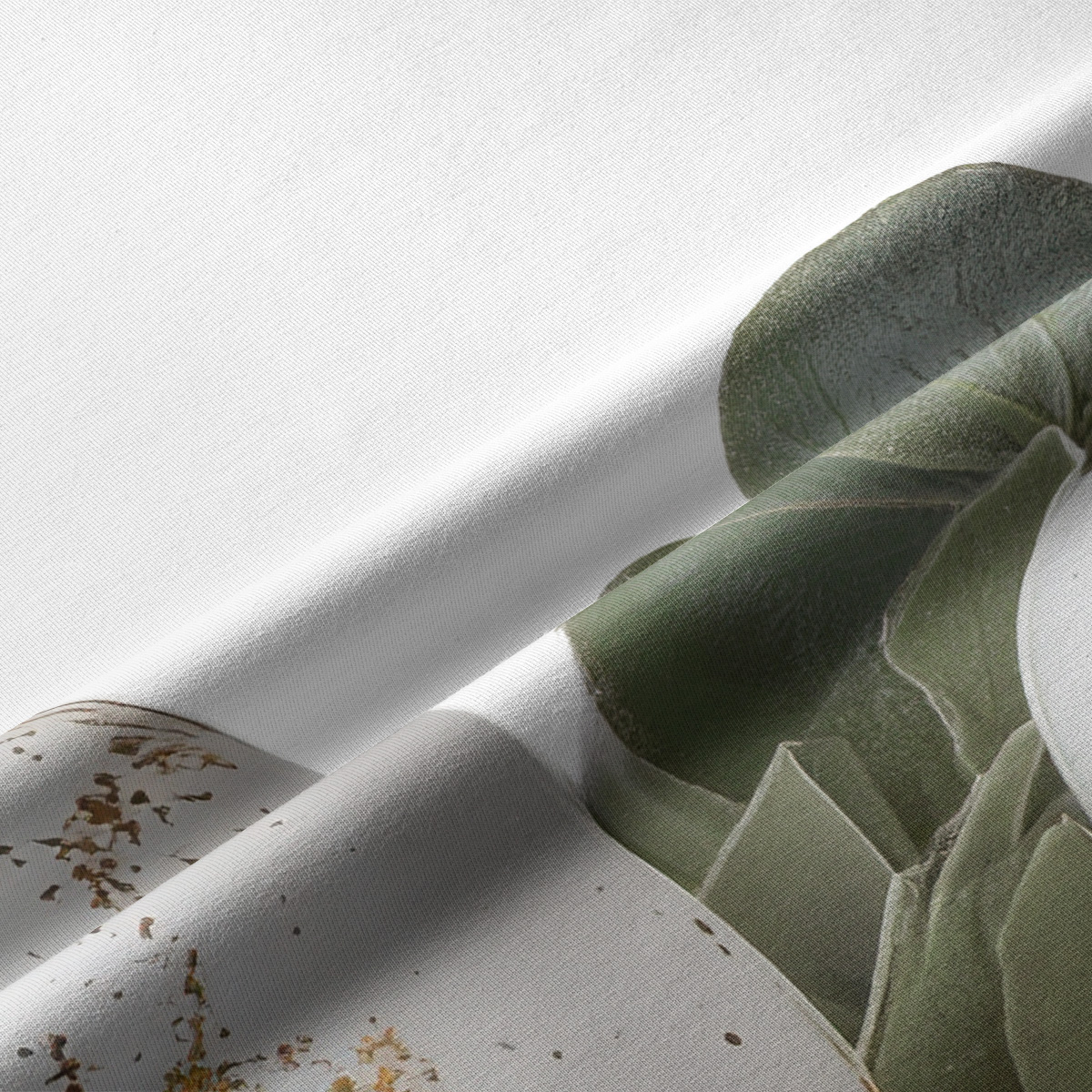 zbliżenie na tkaninę z detalem liści eukaliptusa i subtelnymi złotymi akcentami na pisankach