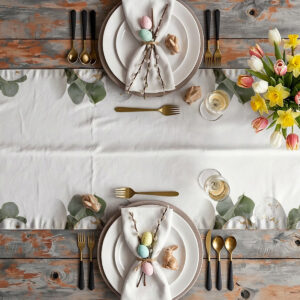 aranżacja stołu z bieżnikiem, talerzami, złotymi sztućcami i wiosennymi kwiatami