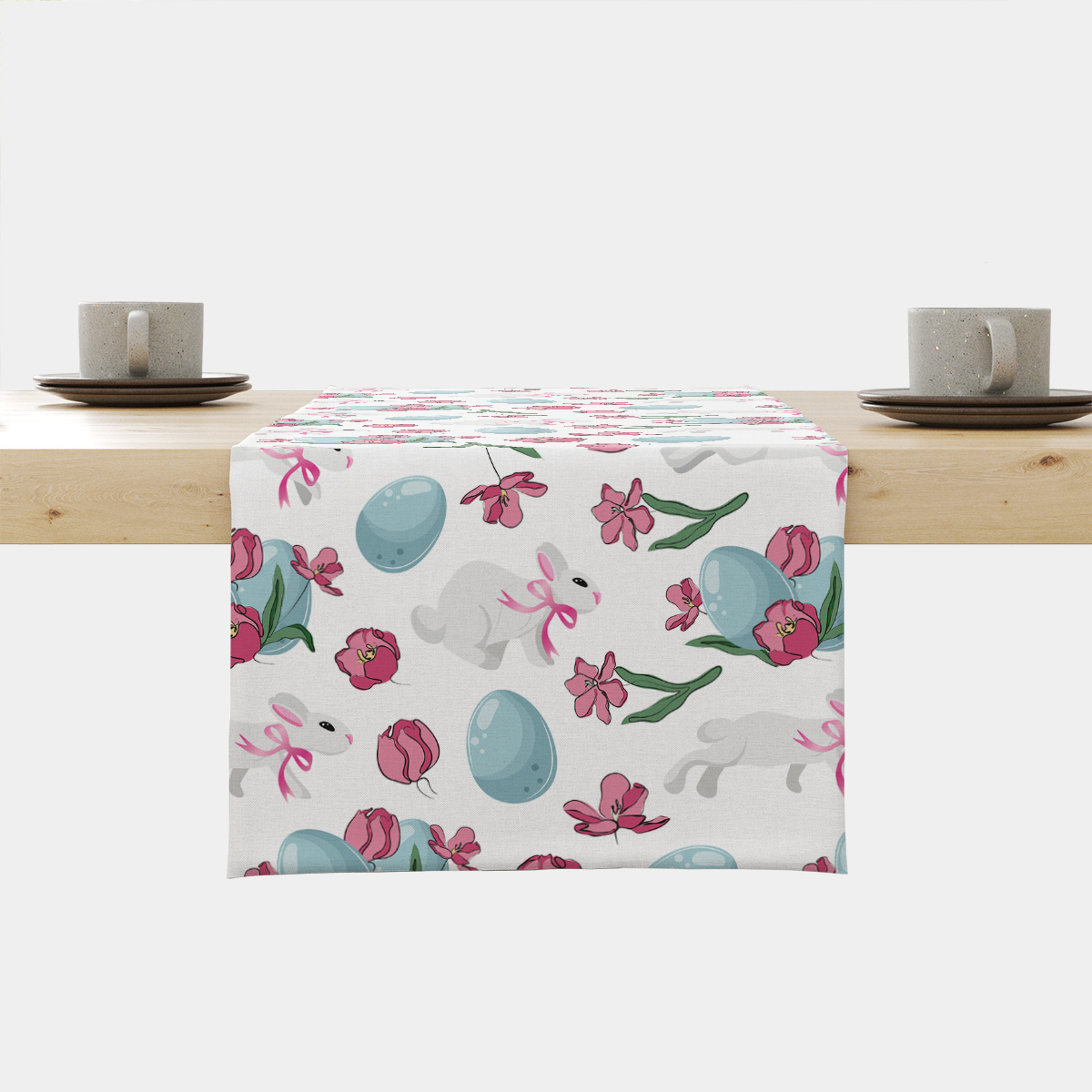 Bieżnik rozłożony na stole z motywem zajączków, niebieskich pisanek i różowych tulipanów