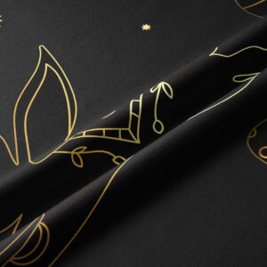 Zbliżenie na złoty metaliczny nadruk z konturami uszu zajączka i detalami pisanki na czarnym materiale