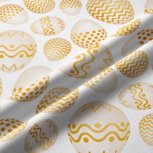 Zbliżenie na tkaninę z nadrukiem złotych pisanek pokazujące fakturę i detale wzoru