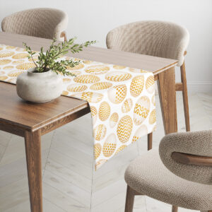 Widok bieżnika na rogu stołu prezentujący powtarzalny motyw złotych pisanek