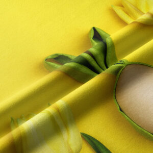 Zbliżenie na fakturę tkaniny z detalem tulipana, liśćmi i stylizowaną pisanką