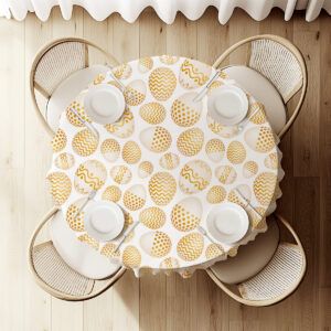 widok z góry na okrągły stół udekorowany obrusem z motywem złotych pisanek