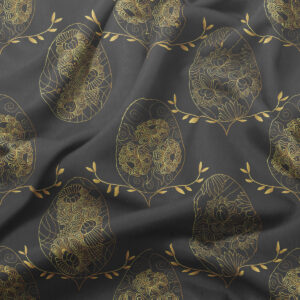 zbliżenie na złociste, ręcznie rysowane pisanki i delikatne gałązki na tkaninie