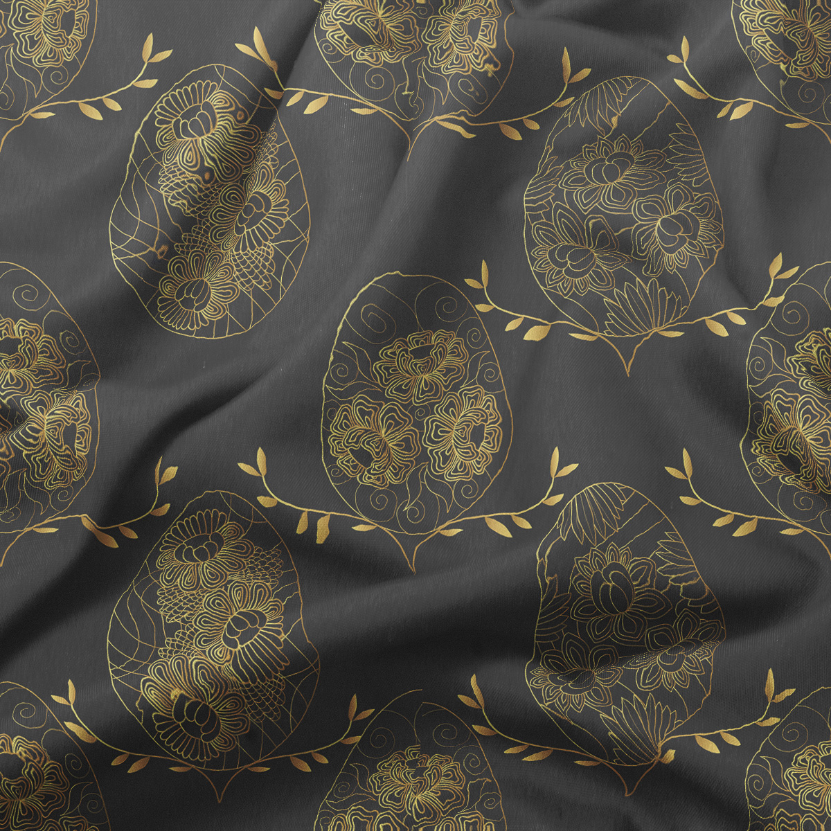 zbliżenie na złociste, ręcznie rysowane pisanki i delikatne gałązki na tkaninie