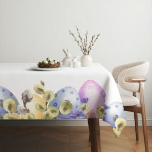 Aranżacja stołu z obrusem, prostą ceramiką, gniazdem z jajkami i gałązkami bazi w tle