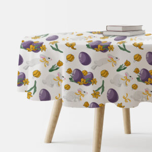okrągły stół nakryty obrusem z wzorem zajączków, fioletowych pisanek i żółtych tulipanów