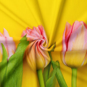 Zbliżenie na tkaninę i szczegóły nadruku różowych tulipanów na intensywnym żółtym tle