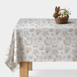 obrus na stole z rysunkowym wzorem zegarków, pisanek i bukiecików oraz wiklinowy koszyk z pisankami