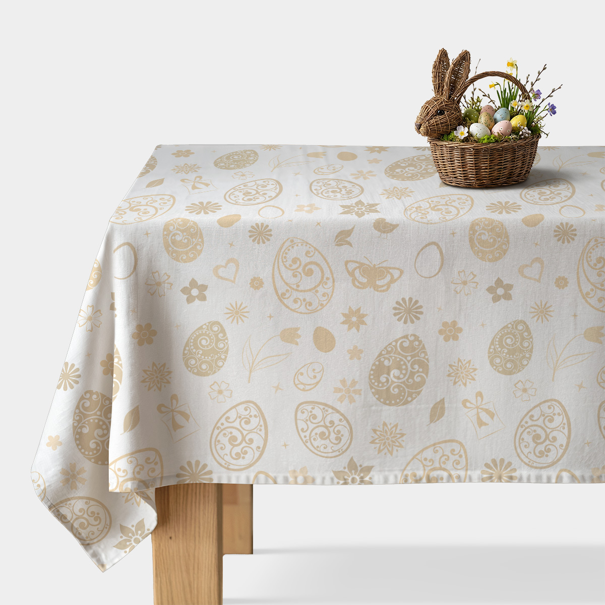 obrus na stole z kremowym wzorem ozdobnych jajek i koszyczkiem z pisankami