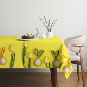 Aranżacja stołu z koszykiem jaj i minimalistycznymi dekoracjami na żółtym obrusie
