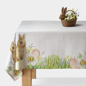 Obrus z widocznym brzegowym motywem zajączka, narcyzów i pisanek rozłożony na stole
