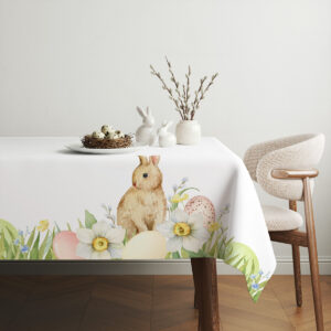Aranżacja stołu z obrusem, koszykiem z jajkami i subtelnymi dekoracjami wiosennymi
