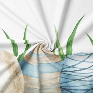 Zbliżenie na tkaninę z akwarelowym wzorem pisanek i detalem zielonych źdźbeł