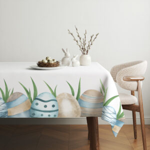 Aranżacja stołu z obrusem, dekoracyjnym gniazdem z jajkami i wiosennymi dodatkami