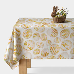 Obrus na stole z wzorem złotych pisanek i plecionym koszykiem z dekoracyjnymi jajkami