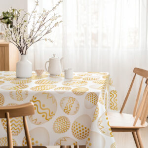 Jasna jadalnia z obrusem w złote pisanki i wazonem z kwiatami