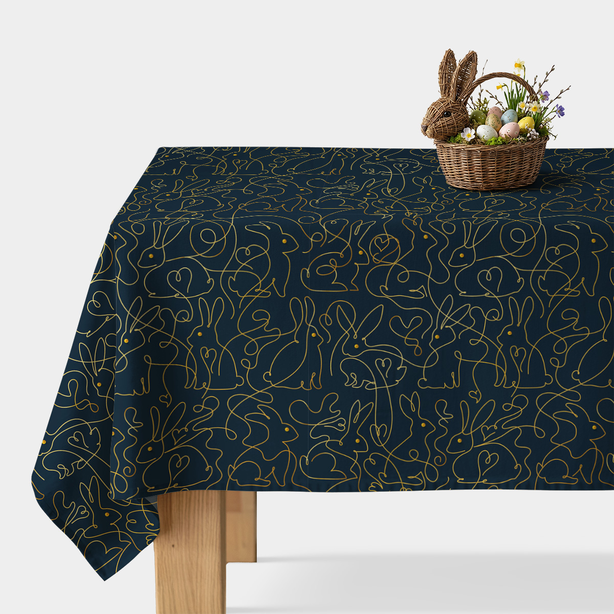 Obrus na stole z granatowym tłem i złotym wzorem króliczków, widok ogólny