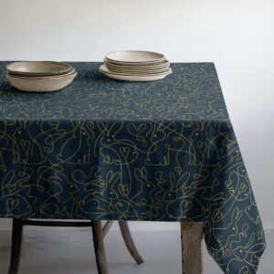 Widok brzegu stołu z talerzami, ornament z zajączkami na granatowym tle