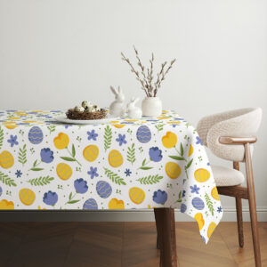 Aranżacja stołu z koszykiem, gałązkami i obrus z wiosennym motywem