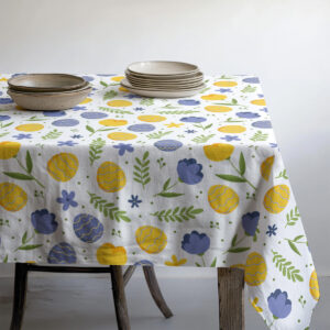 Stół nakryty obrusem z drobnymi jajkami i kwiatowym wzorem w stylu świątecznym