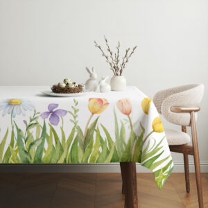 Stół nakryty obrusem z wiosennym wzorem, dekoracje wielkanocne z jajkami i gałązkami