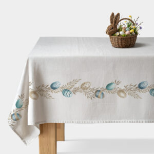 Biały obrus z pasem pastelowych pisanek i delikatnych beżowych gałązek na drewnianym stole