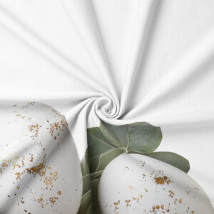 zbliżenie na detale nadruku: białe pisanki ze złotymi plamkami i zielone liście eukaliptusa