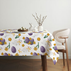 Aranżacja stołu z dekoracją i ceramicznymi zajączkami na obrusie w wiosennym wzorze