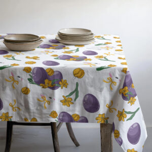 Szczegół wzoru na rogu stołu pokazujący pęk fioletowych pisanek i żółte kwiaty