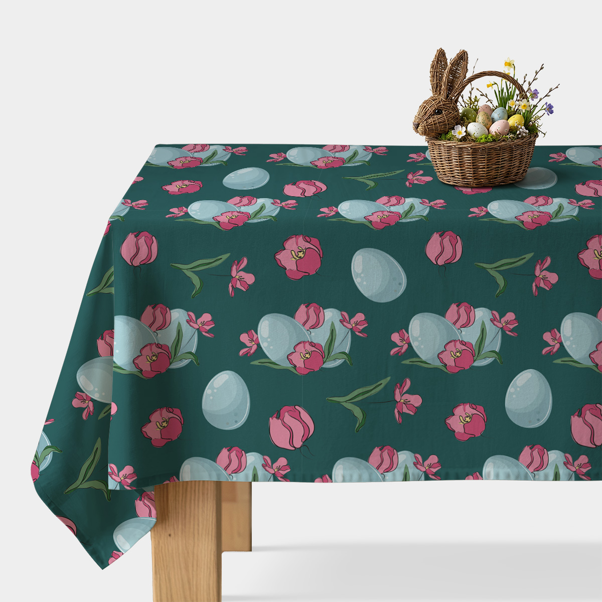 Obrus z ciemnozielonym tłem ozdobiony różowymi tulipanami i pastelowymi pisankami, główne ujęcie stołu