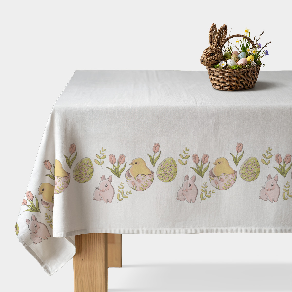 Obrus z pastelowym motywem pisanek, kurczaczków i zajączków na białym tle, widok na stół