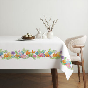 Aranżacja stołu z prostą dekoracją: obrus z ozdobnym pasem i subtelnymi wielkanocnymi elementami