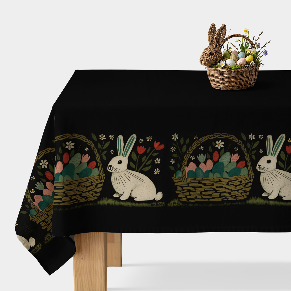 Obrus na stole z czarnym tłem i powtarzającym się brzegiem z białymi zajączkami oraz koszykami pełnymi pisanek