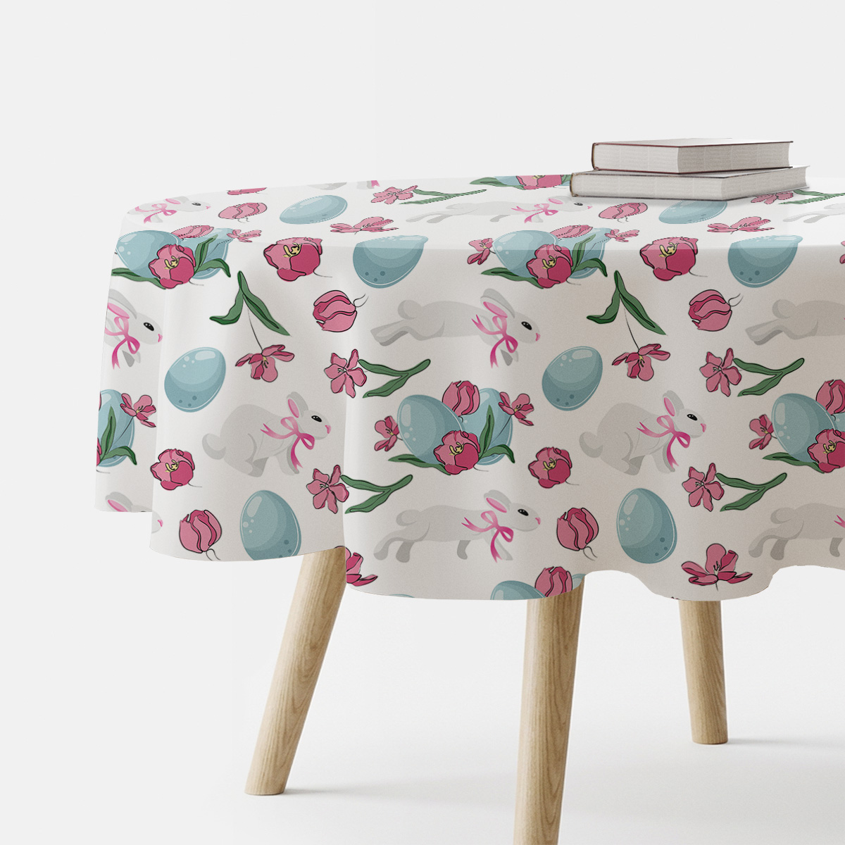 Okrągły obrus z wzorem zajączków, niebieskich pisanek i różowych tulipanów na stole, widok boczny